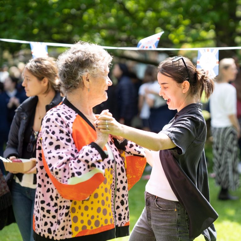 Queen's Gate Sneior School girl dancing with Age UK member at Coronation celebrations